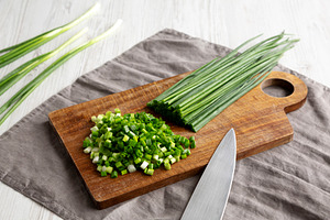 Organic Cut Green Onion Scallions on a Wooden Board, side view., a Food & Drink Photo by LiudmylaChuhunova