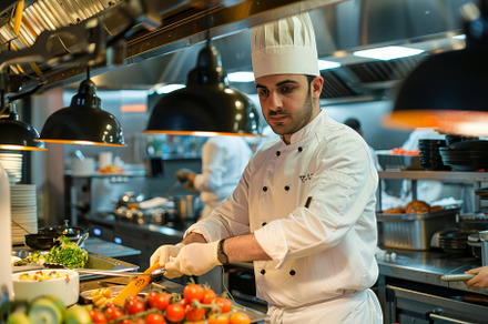 Chef preparing fresh ingredients in, a Photo by Tanuart