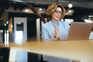 Business woman waving on a video call in a coworking office, a Person Photo by Jacob Lund