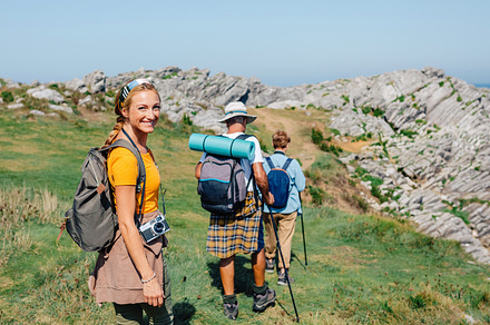 Happy young woman looking camera hiking with her grandparents, a Holiday Photo by davidpereiras