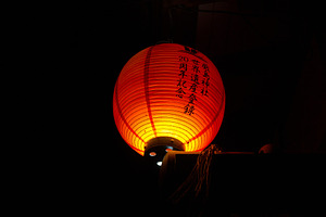 Traditional Japanese lantern glowing at night on Miyajima island, an Abstract Photo by GoodGoods