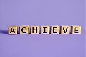Achieve word on wooden cubes blocks, a Business Photo by Gladkov photography