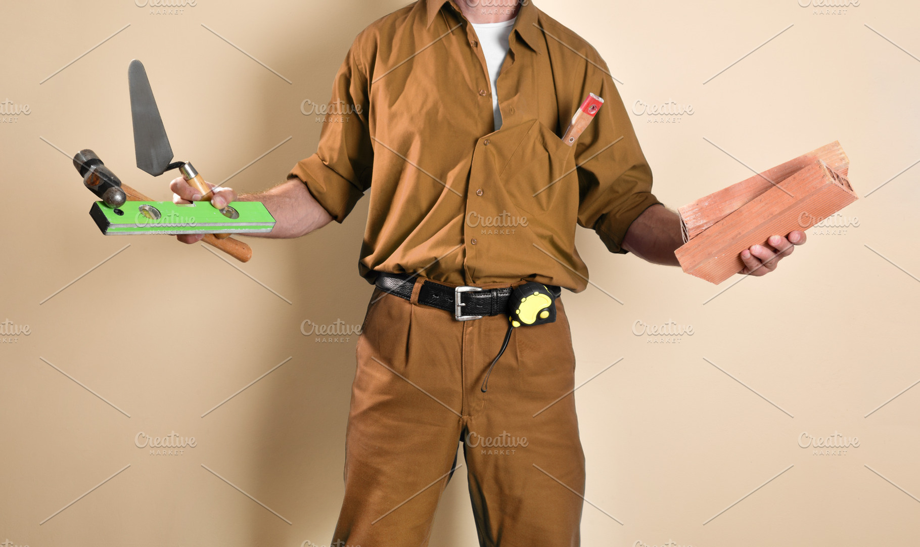 Detail of mason with tools in hands isolated brown background, a Person Photo by Davizro's Market