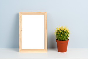Cactus in pot and wooden photo frame