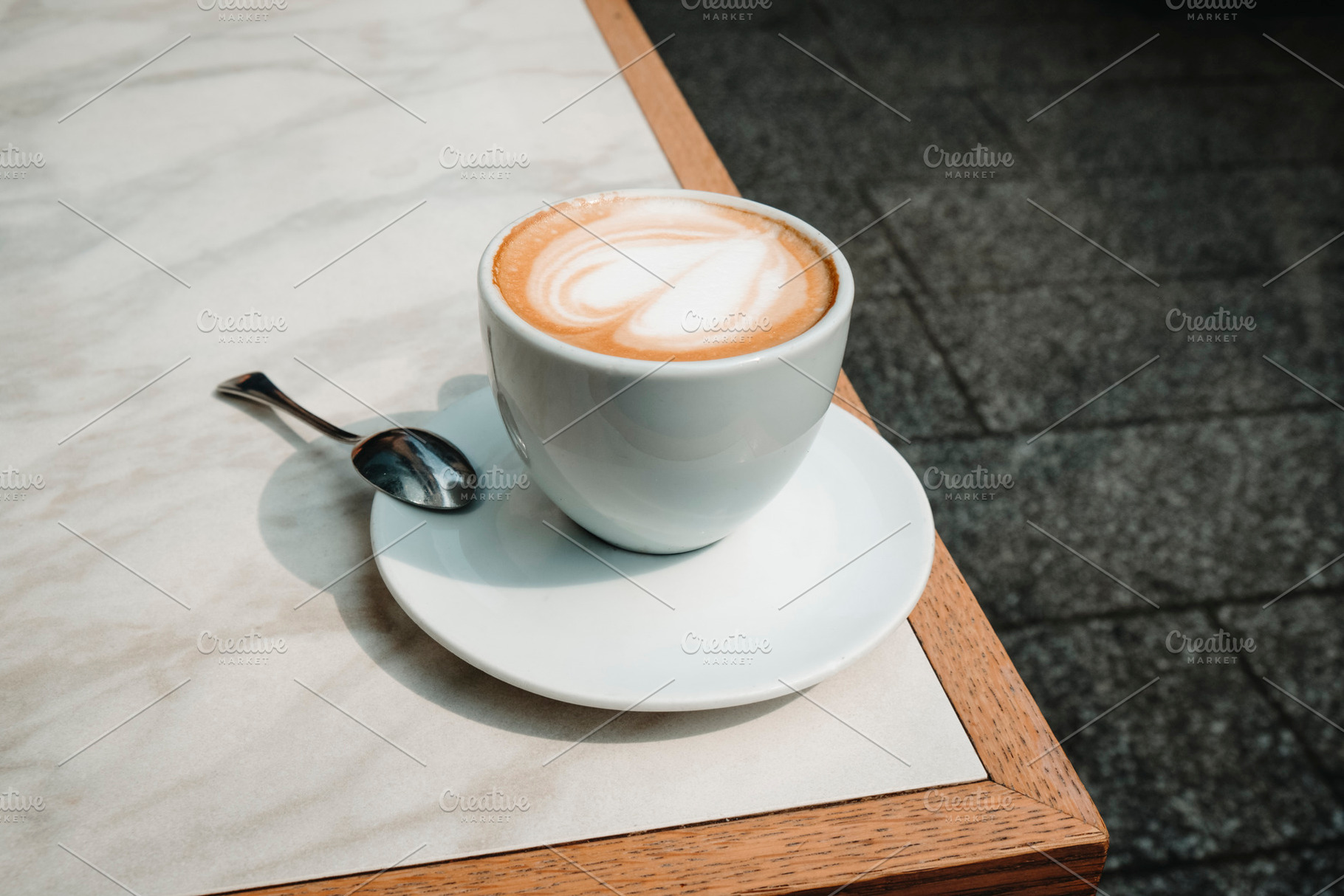 closeup of macchiato with heart foam on cafe table, a Photo by Nito