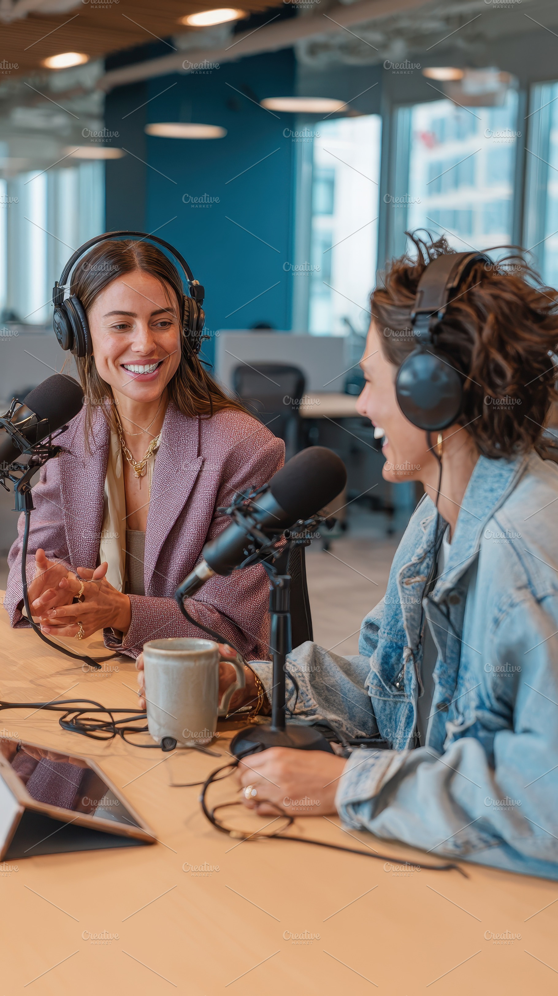 Two women podcasting in a modern off, a Photo by Pixeness Studio