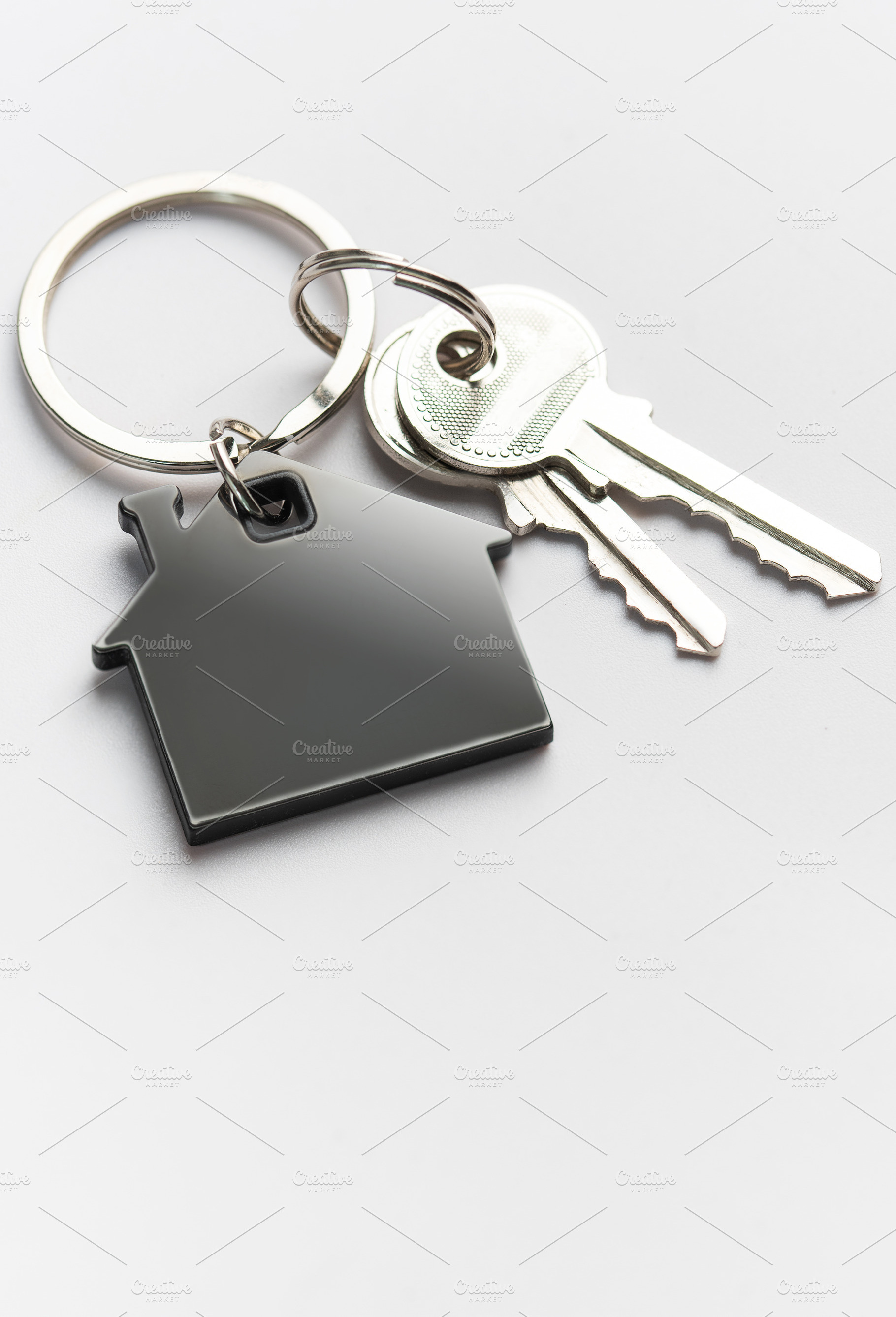 House keys with home shape keychain on white background, a Business Photo by Olena Rudo