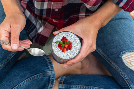Female hands holding chia pudding with fresh strawberries for breakfast, a Food & Drink Photo by Antonina Vlasova