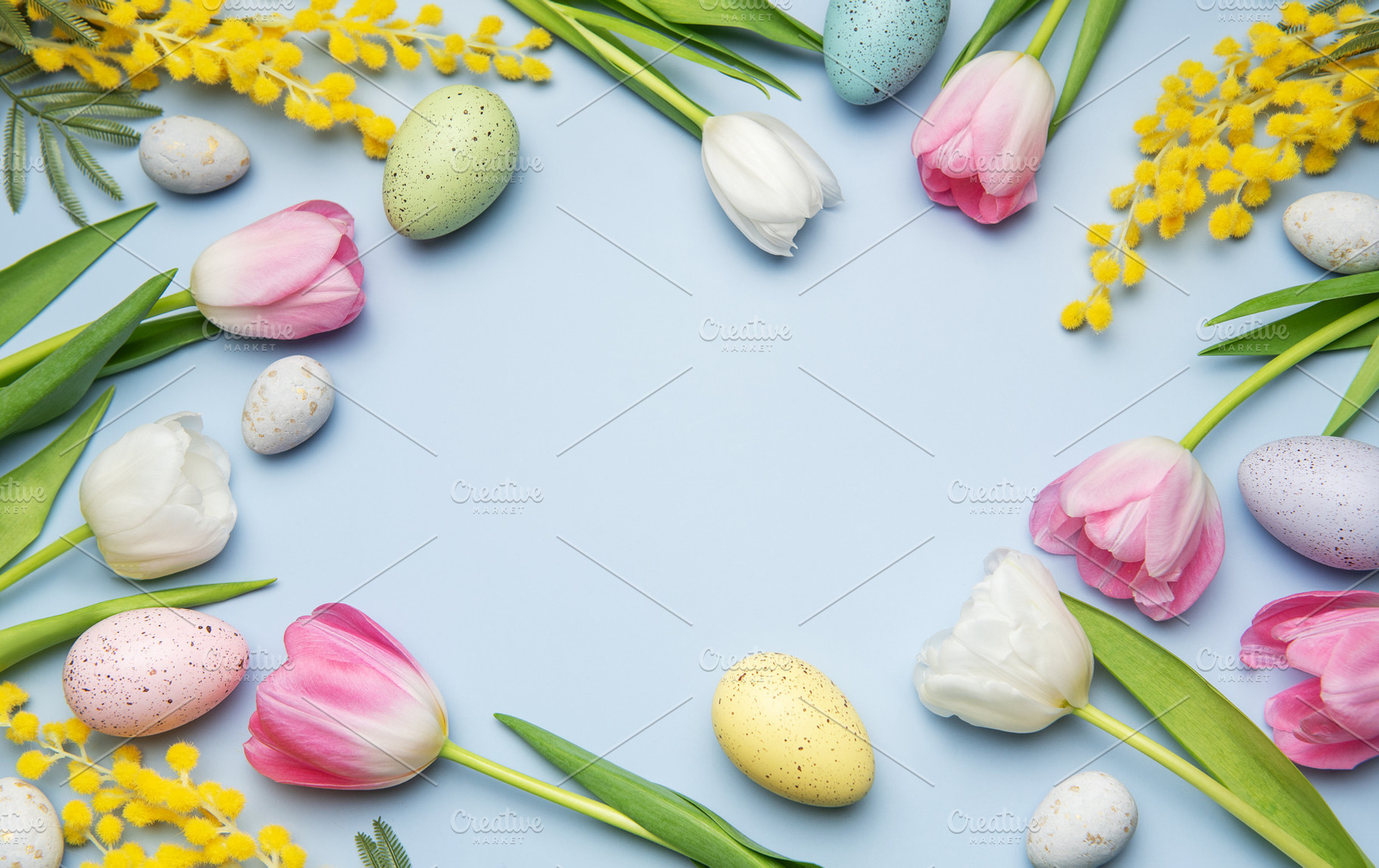 Easter eggs and tulips forming a frame on light blue background, a Photo by Olena Rudo