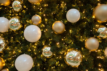 Closeup of Christmas tree decorated with shiny balls and fairy lights, a Photo by andreonegin market