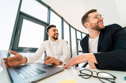 Smiling men working in office, a Photo by borodai94