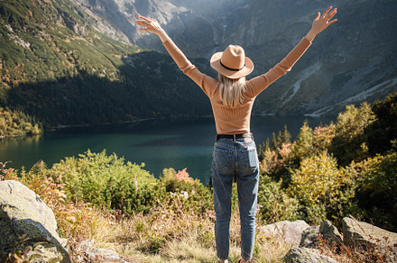 Young tourist woman in a hat with hands up on the top of the mou, a Sports & Recreation Photo by Olena Rudo