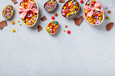 Chocolate Easter eggs and candy on concrete table, festive Easter background fl, a Holiday Photo by Maria Shipakina