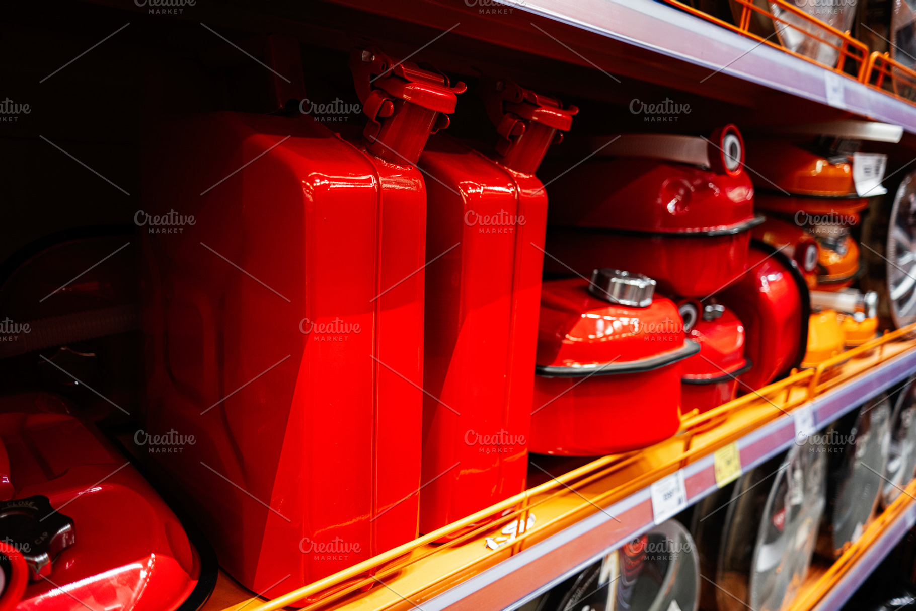 Red metal fuel containers on display in a hardware store shelf section, a Photo by AS photostudio