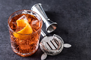 Americano cocktail garnished with twist orange on black slate background, a Food & Drink Photo by etorres69