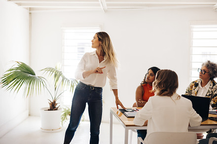 Team leader sharing her ideas with her colleagues in an office, a Person Photo by Jacob Lund