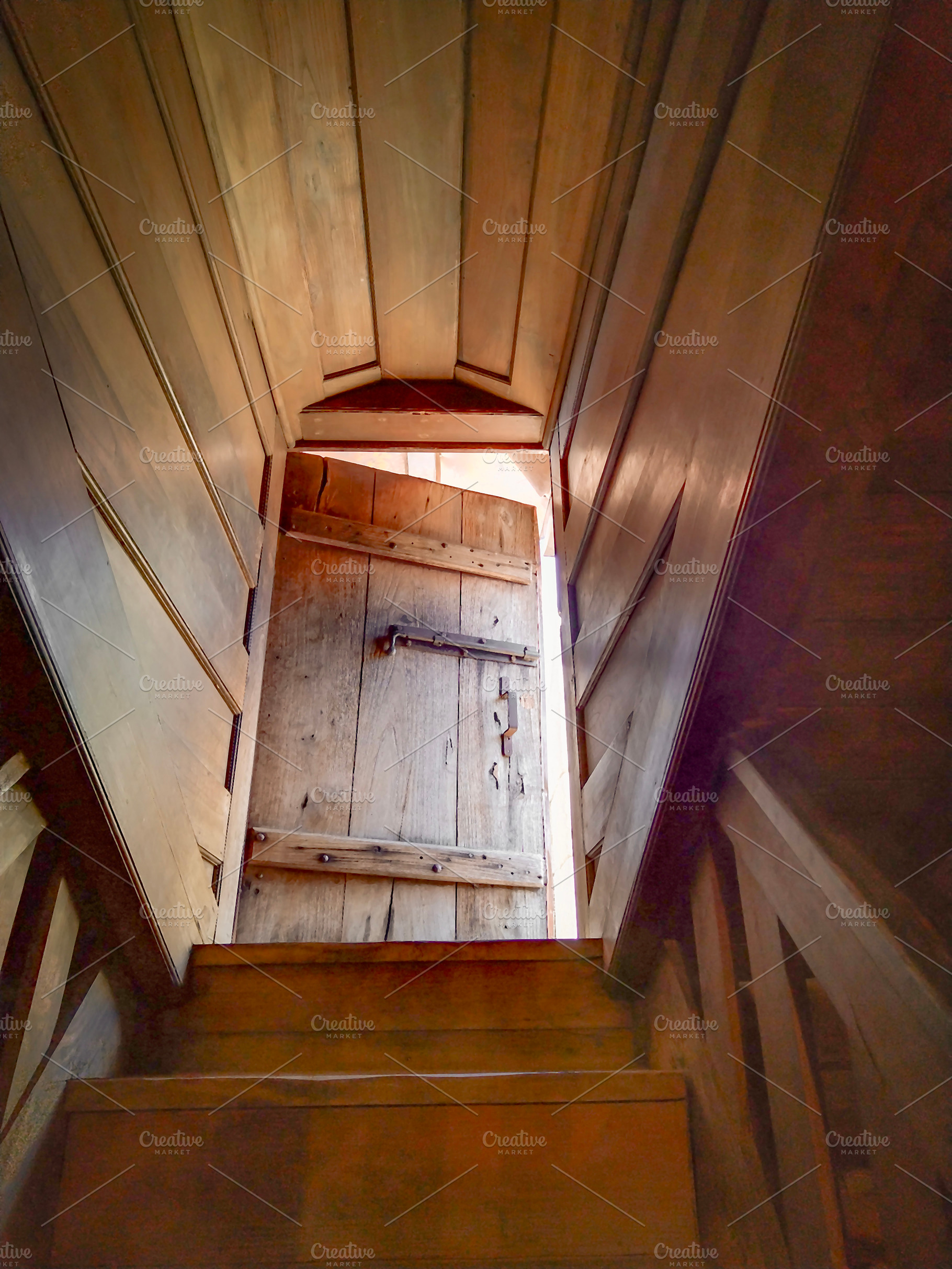 Wooden stairs leading to door with warm light, an Architecture Photo by DanFLCreativo