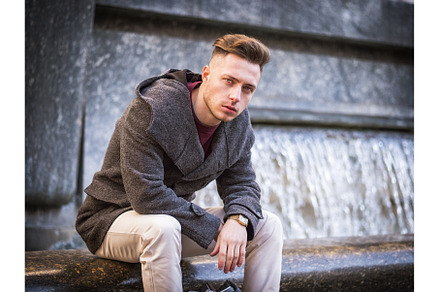 Young man sitting by fountain, a Person Photo by ArtOfPhotos photo store