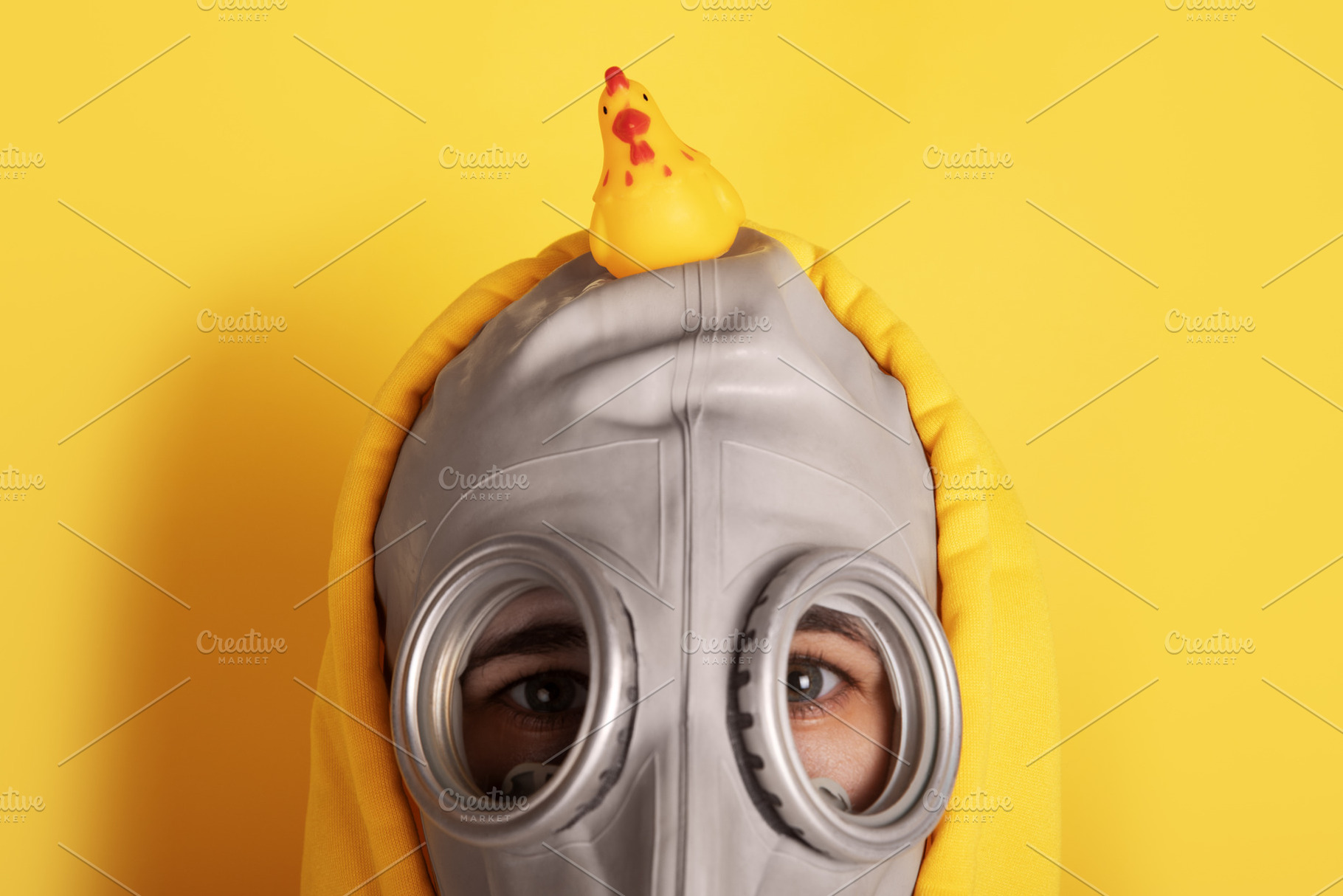 Close-up of a person in a gray gas mask and yellow hoodie with a, a Person Photo by Ales Munt