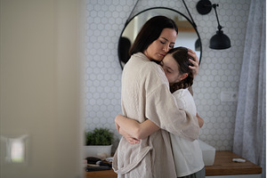 Mom hugging daughter during, a Person Photo by HalfPoint