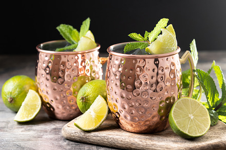 Moscow mule cocktail served with ice and lime slice on wooden table., a Food & Drink Photo by etorres69