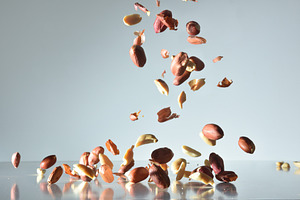 Peanuts falling on a gray reflective base with isolated backgrou, a Food & Drink Photo by Davizro's Market