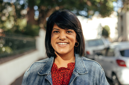 Cheerful woman smiling at the camera outdoors, a Person Photo by Jacob Lund