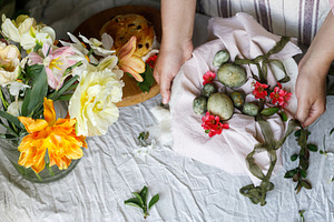 Easter celebration. Hands holding stylish green easter eggs on n, a Holiday Photo by Sonjachni
