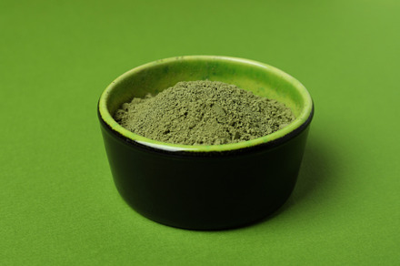 Bowl of matcha powder on green background, a Food & Drink Photo by AtlasStudio PRO