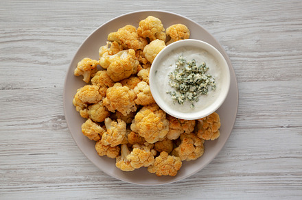 Homemade Buffalo Cauliflower with Blue Cheese Sauce, top view., a Food & Drink Photo by LiudmylaChuhunova