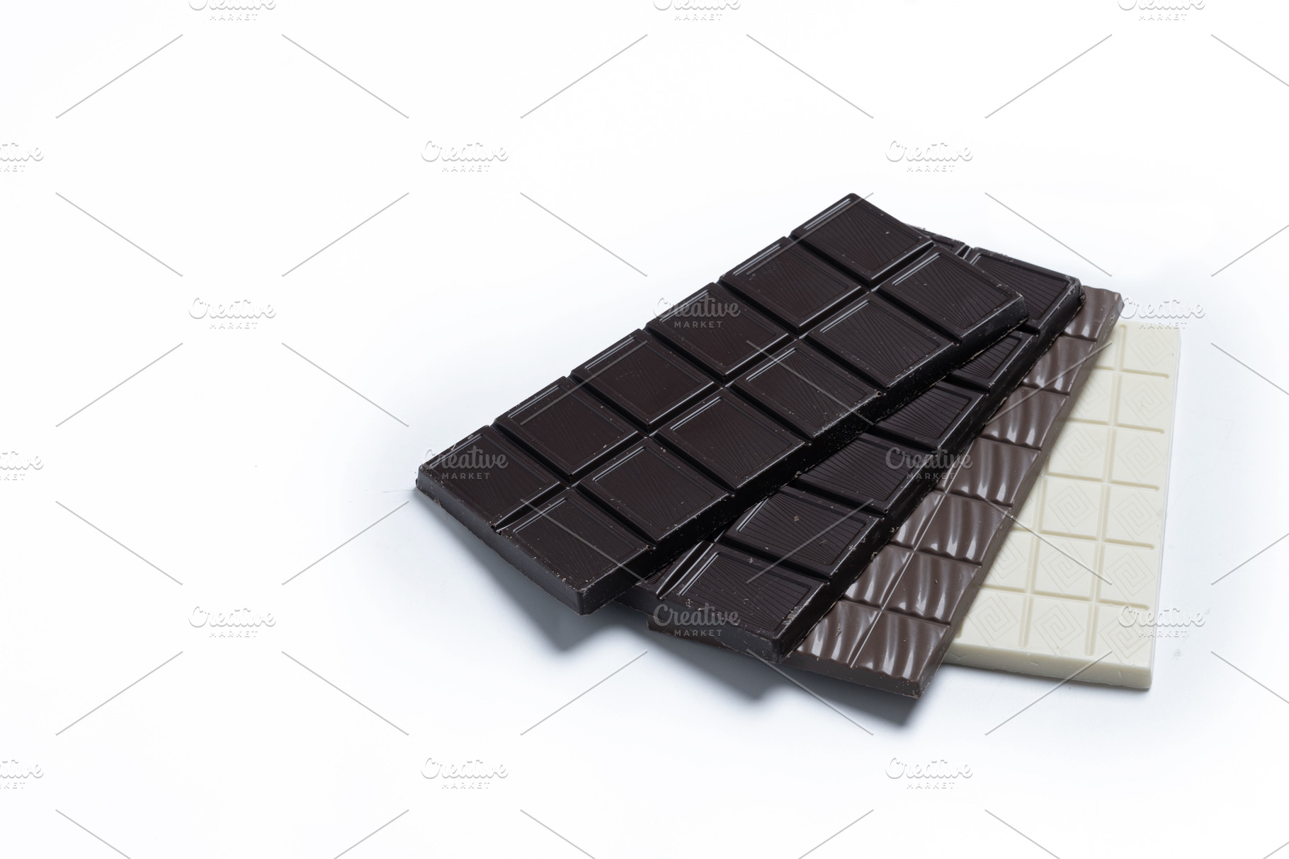 Assortment of white, milk and dark chocolate pieces isolated on white backgroun, a Food & Drink Photo by etorres69