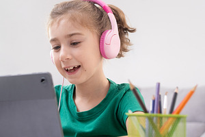 Young Girl Watching Tablet with pink headphones, a Person Photo by etorres69