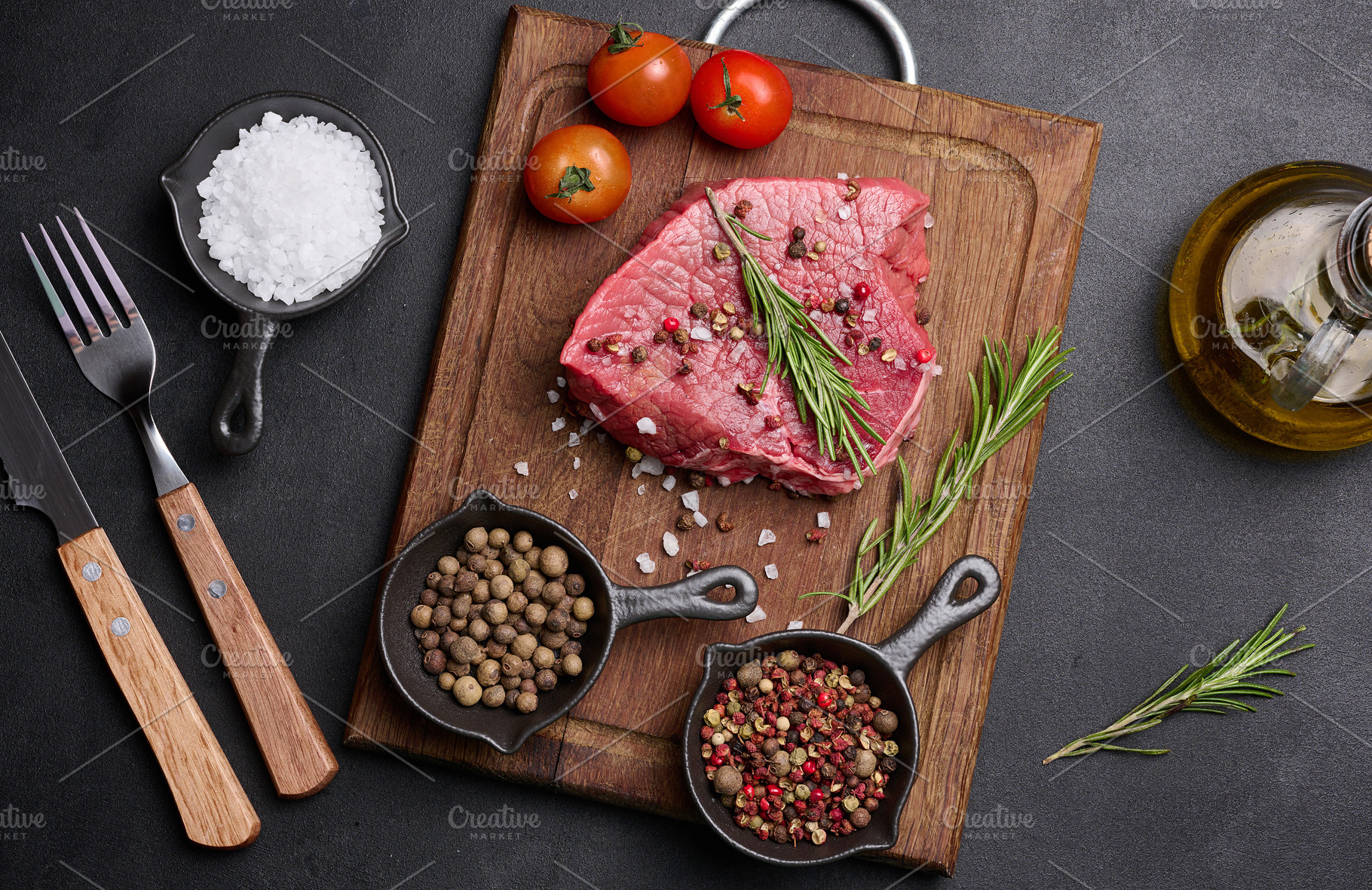Fresh piece of raw beef on a wooden board with rosemary, cherry, a Food & Drink Photo by ndanko
