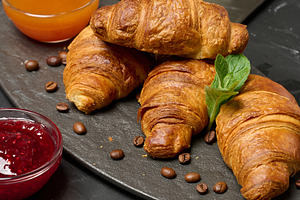 Baked croissant on black board, delicious breakfast,, a Food & Drink Photo by ndanko