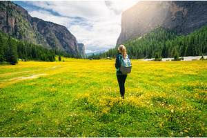 Girl with backpack on the meadow, a Person Photo by den-belitsky