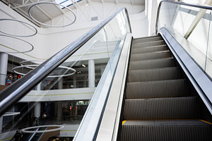 Modern escalator in a bright shopping mall with sleek interior design, a Photo by AS photostudio