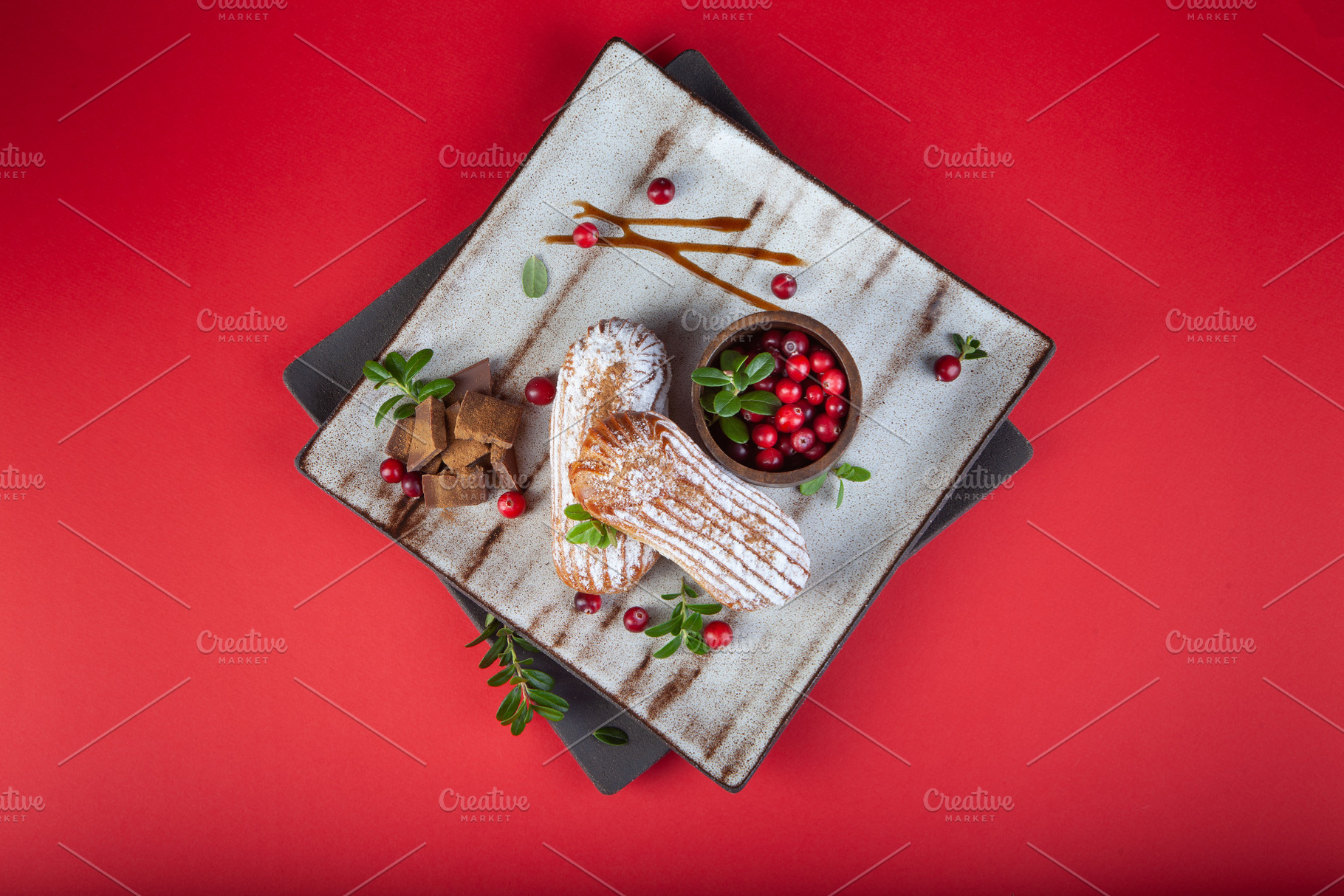Cream eclairs choux pastries served with fresh cranberries on a, a Food & Drink Photo by eleana