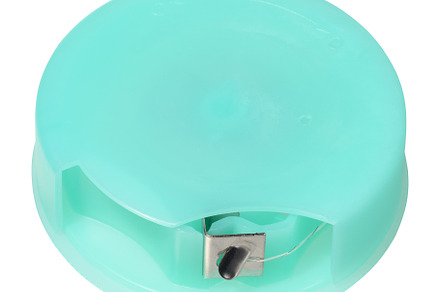 Round, mint green dental floss container with a metal cutter, de