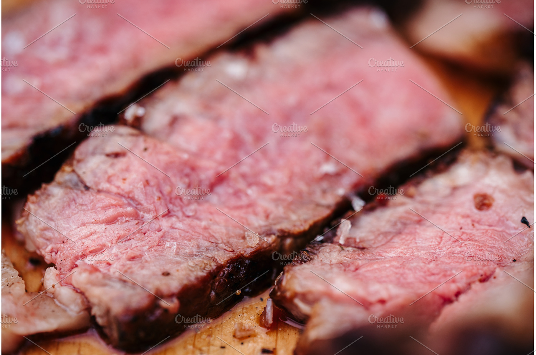 Sliced grilled steak on wooden, a Food & Drink Photo by HalfPoint