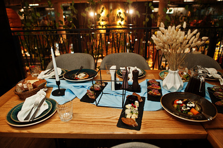 Beautifully laid tables with food, glasses and appliances in res, a Food & Drink Photo by AS photostudio