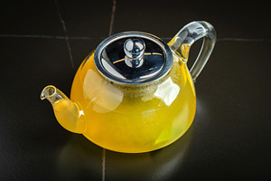 Fruit tea with mango and mint in a glass teapot on the table, a Food & Drink Photo by Budarinphoto