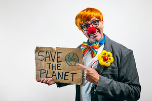 Clown holding save the planet sign advocating environmental awareness, a Person Photo by karrastock