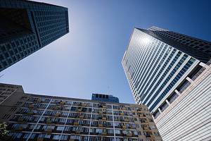Modern skyscrapers and residential buildings under a clear blue sky, a Photo by AS photostudio
