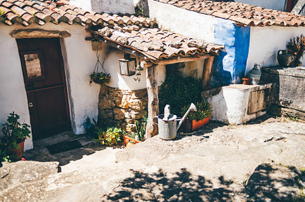 Charming rustic Mediterranean courtyard with traditional whitewashed stone wall, an Architecture Photo by SkyNext