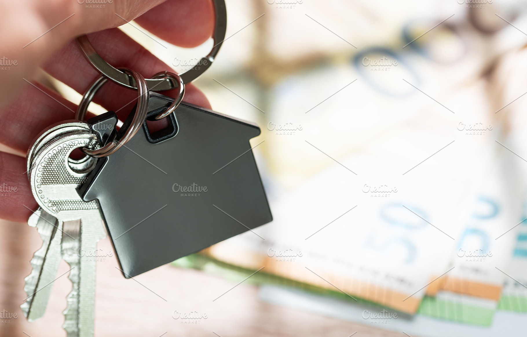 Hand holding house keys with money background, a Business Photo by Olena Rudo
