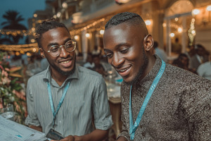 Two black friends enjoying a lively evening at a festive outdoor gathering, an Industrial Photo by AS photostudio