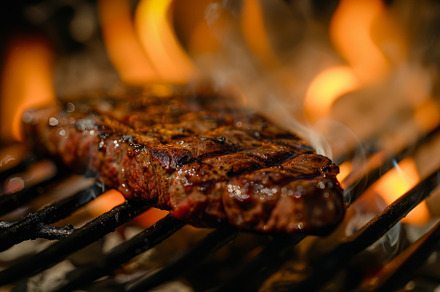 A steak sizzling on a grill with fla, a Photo by Iftikhar Alam