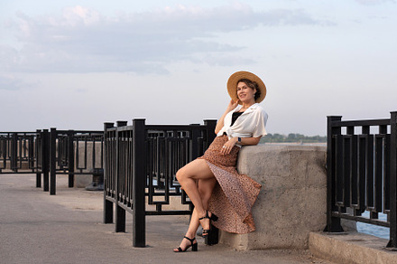 Woman smiles while leaning on stone