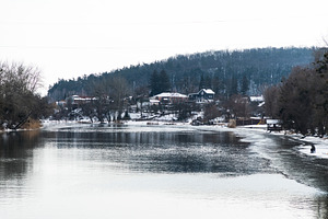 Houses in winter forest near river f, a Nature Photo by FineArtStudio
