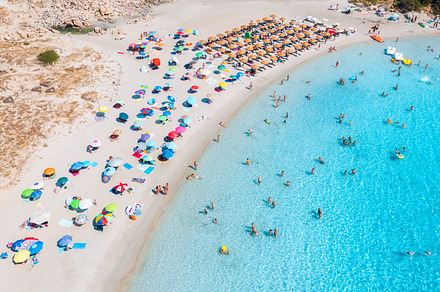 Aerial view of colorful umbrellas on beach, people in blue sea, a Nature Photo by den-belitsky